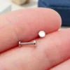 plain-disc-nose-stud-on-fingertip-scale Plain disc top and flat back post resting on a fingertip, showing their small size