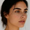 plain-disc-nose-stud-worn-on-model Woman wearing a small plain disc stud in her nostril